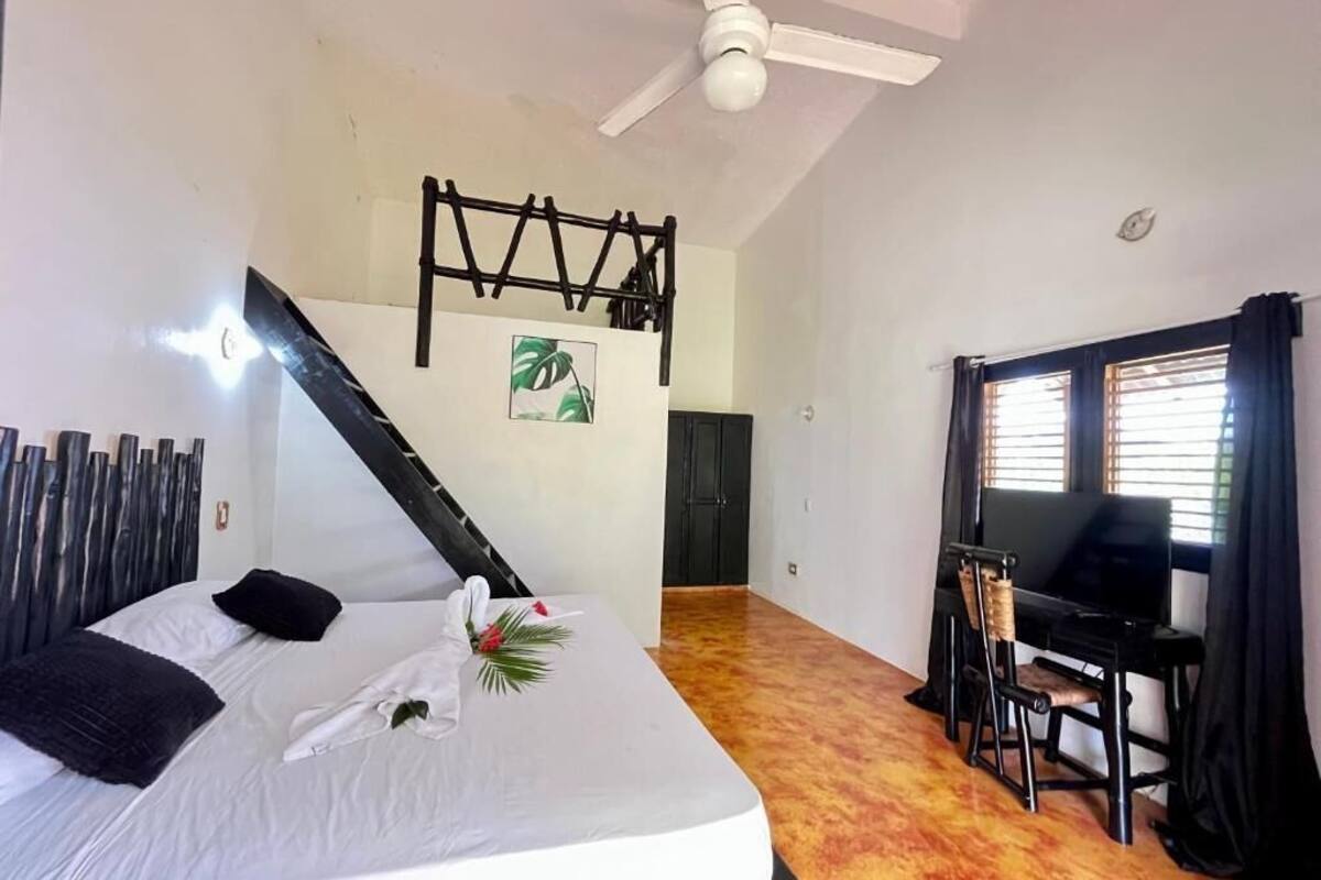 A bedroom with a bed, a desk, and a chair.