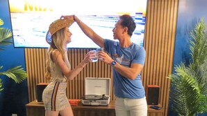 A room with a wooden reception desk, a television, and a glass table with food. - Jungle Fun House, Karaoke, Minutes to Broadway (Nashville)