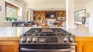 A modern kitchen with a central island, built-in shelves, and a dining area with a table and chairs. - Huge 2Br/2Ba Unit w/Pvt Deck + 5 min to Ocean (Richmond)