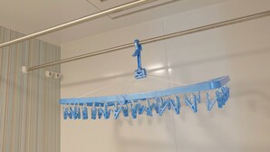 A ceiling-mounted drying rack with multiple clips for hanging clothes. - Heath Miyakojima (Miyakojima)