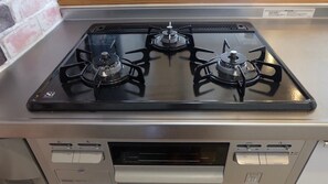 A kitchen with a gas stove, oven, and a built-in microwave. - Heath Miyakojima (Miyakojima)