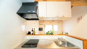 A modern kitchen with a built-in stove, a sink, and white cabinets. - Miraie Yokkaichi Hinaganishi (Yokkaichi)