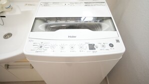 A white Haier washing machine in a bathroom. - Miraie Yokkaichi Hinaganishi (Yokkaichi)