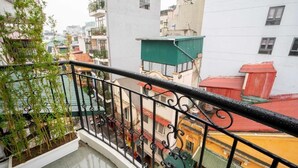 A balcony with a metal railing overlooking a densely packed urban area with colorful buildings. - Charming Moon Hotel (Hanoi)