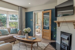 Ein modernes Wohnzimmer mit Sofa, Couchtisch und Kamin.
