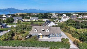 Un quartier résidentiel avec des maisons, une allée et une vue sur la mer et les montagnes.