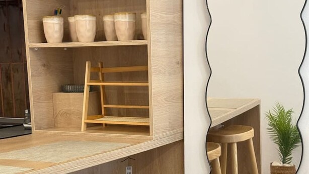 Una cocina moderna con taburetes de madera, barra y un salpicadero de espejo.