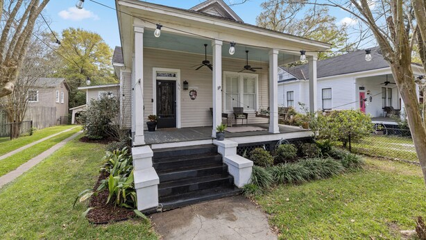 A white house with a porch, steps, and a front door.