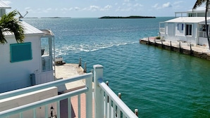 A waterfront property with a white building, a dock, and a clear view of the sea. - Casa Key Lime  VO291 Bring your boat (Cudjoe Key)