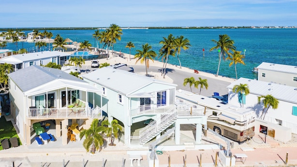 A beachfront property with multiple buildings, a pool, and palm trees. - Casa Key Lime  VO291 Bring your boat (Cudjoe Key)