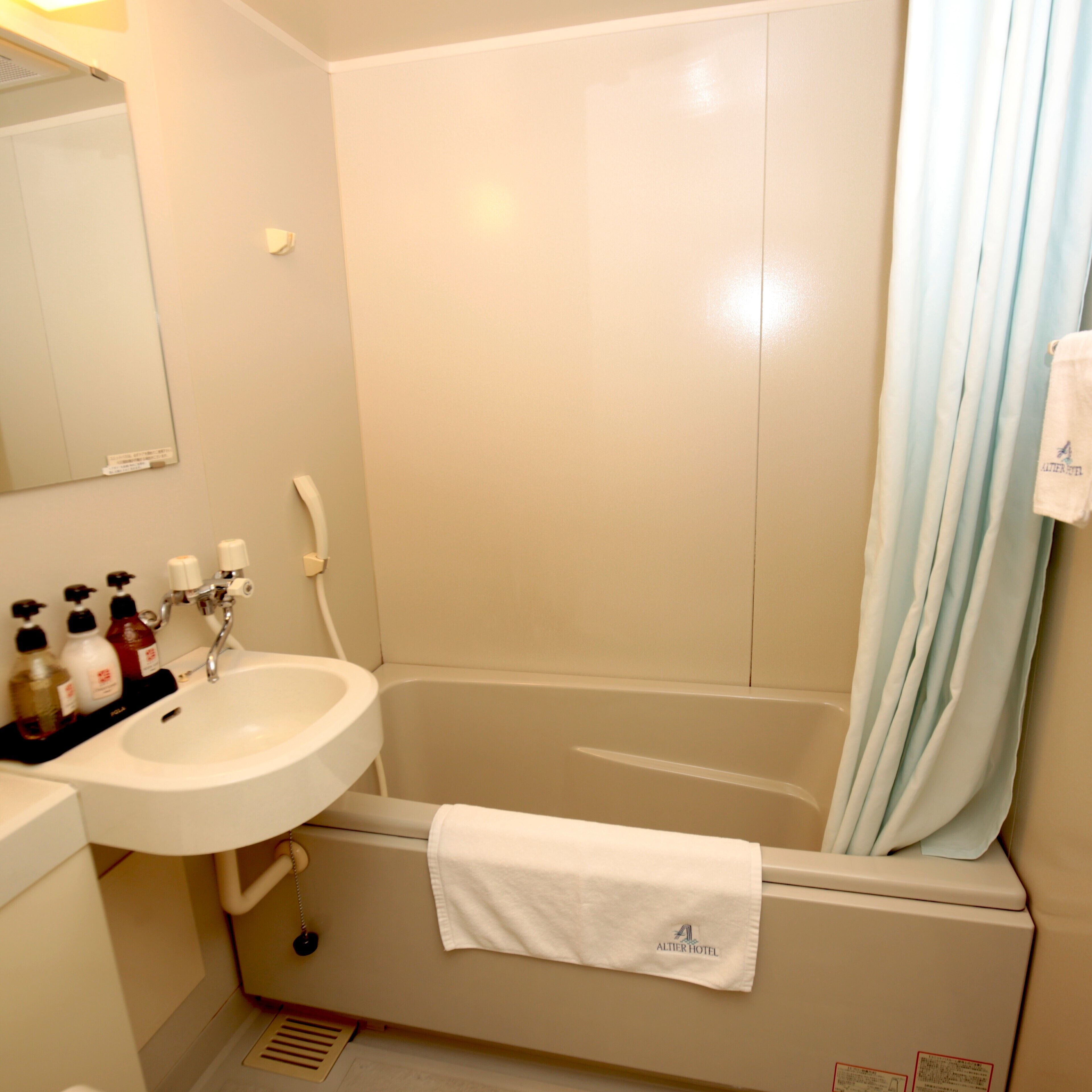 Une salle de bain avec un lavabo, un miroir et une baignoire.