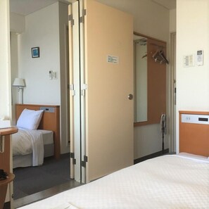 A hotel room with a bed, bedside table, lamp, and a mirror. - Altier Hotel Kii Tanabe (Tanabe)
