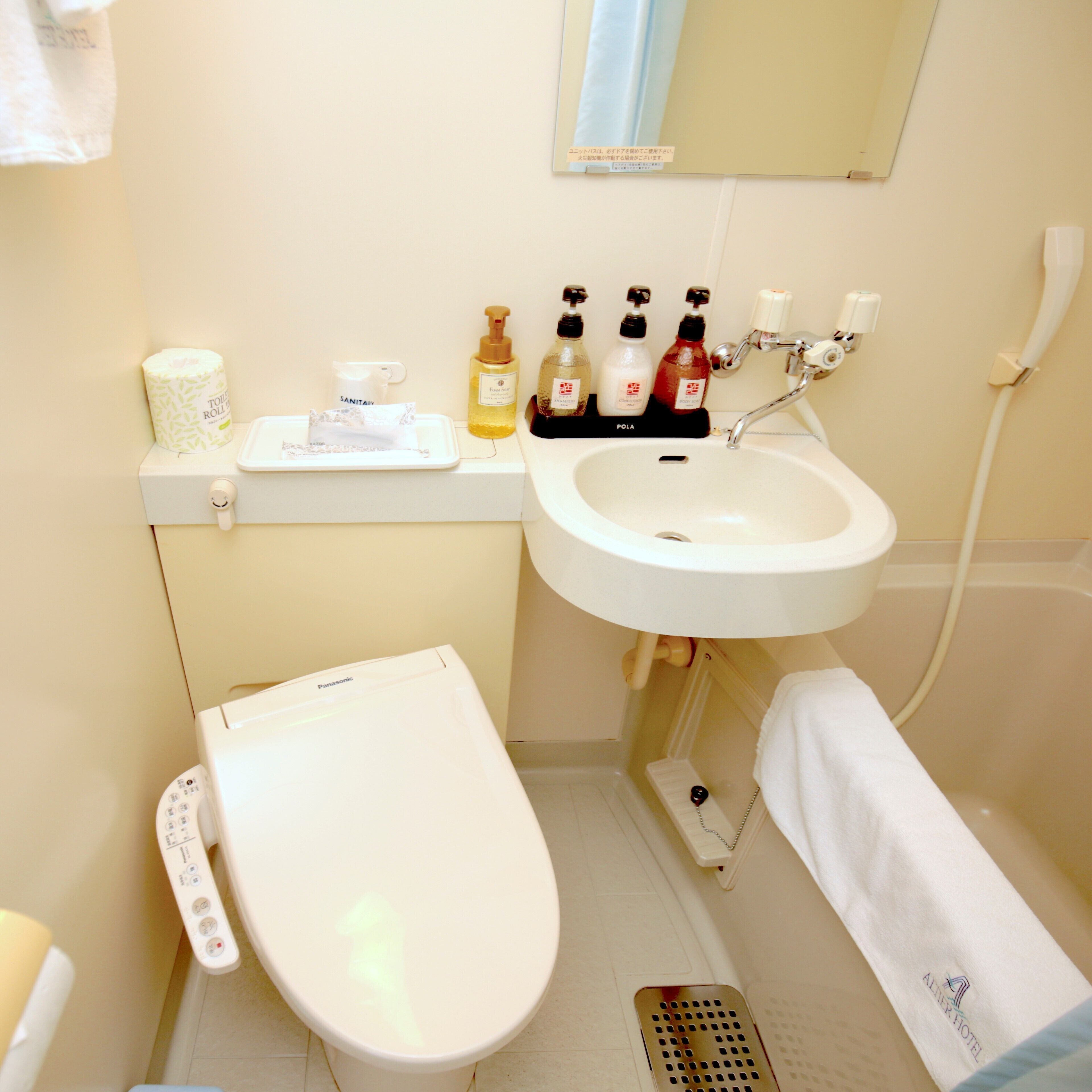 A bathroom with a toilet, sink, and various toiletries.