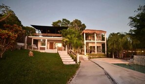 A two-story house with a pool, surrounded by greenery and a well-maintained lawn. - Hotel Aldaria Bacalar (Bacalar)