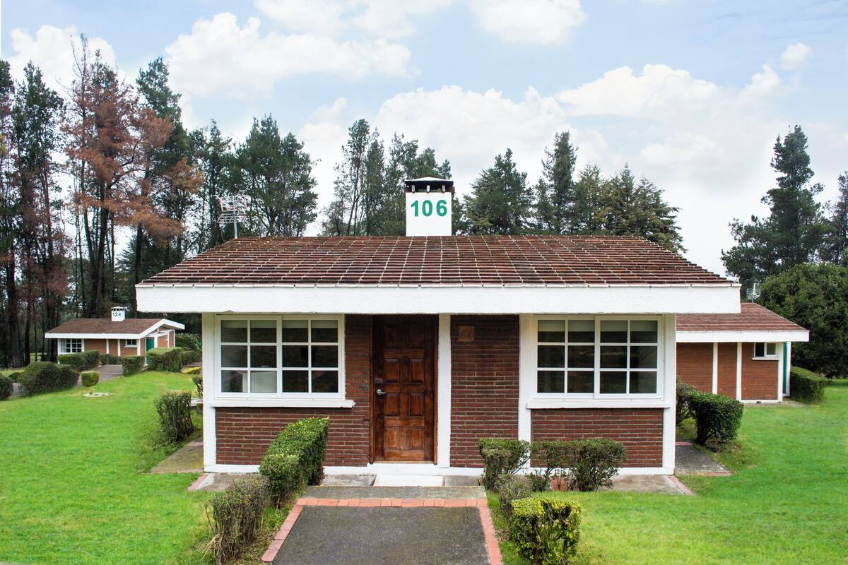 A two-story building with a red-tiled roof and a number 106 sign on top.