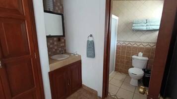 Une salle de bain avec un lavabo, un miroir et des toilettes.