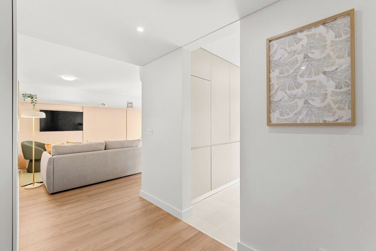 A modern interior with a sofa, a flat-screen TV, and a framed artwork on the wall.