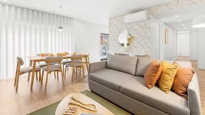 A modern living room with a sofa, dining table, and chairs. - Urban Comfort @ Bonfim Boutique Flats (Porto)