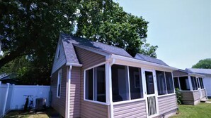 Een gelijkvloers huis met een overdekte veranda, een voordeur en een kleine voortuin.