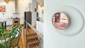 A modern kitchen with white cabinets, a stainless steel oven, and a red pot on the stove. - 2BD/2BA Palisades Townhouse Monthly Rental (Los Angeles)