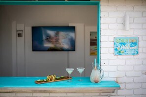 A beach bar with a turquoise counter, a welcome sign, and a painting on the wall. - NEW Ocean Retreat - with pizza oven! (Ocean Grove)