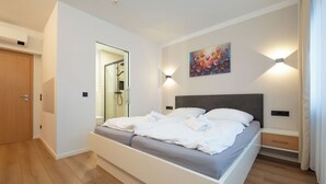 Une chambre à coucher moderne avec un lit, une douche et un tableau au mur.