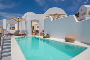 A pool area with white walls, lounge chairs, and umbrellas. - Villa - Sleeps 3 - Private pool-Parking (Megalochori)