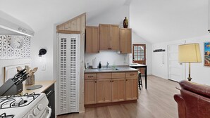 Une cuisine de taille réduite, avec des meubles de rangement en bois, une cuisinière et un évier.