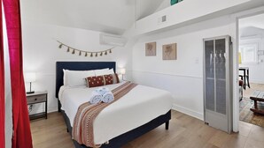 Une chambre bien rangée, avec un lit, des tables de chevet et un ventilateur de plafond.