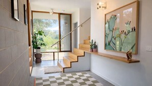 Un escalier moderne avec des marches en bois et une porte en verre donnant sur un balcon.