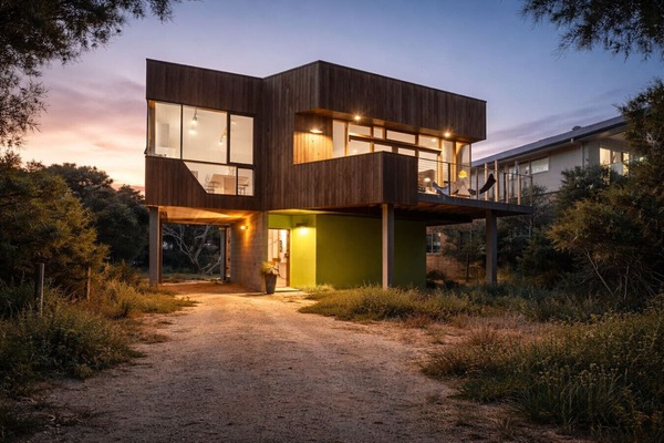 Exterior view of the architect-designed home, beautifully lit for relaxed coastal evenings.