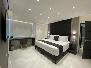 Ein modernes Schlafzimmer mit einem großen Bett, Nachttischen, einem Schreibtisch und einem Spiegel.