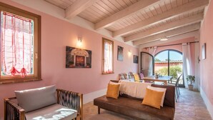 Una habitación acogedora con sofá, sillón, mesa y vistas al exterior.