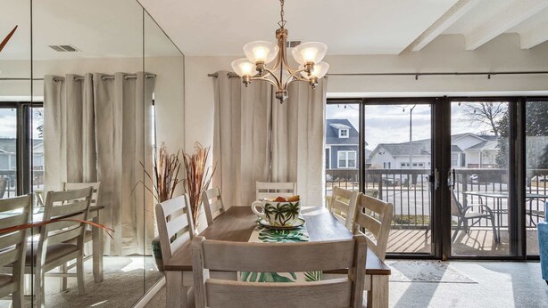 A dining area with a wooden table, chairs, and a chandelier. - Tiburon 1B (Ocean City)