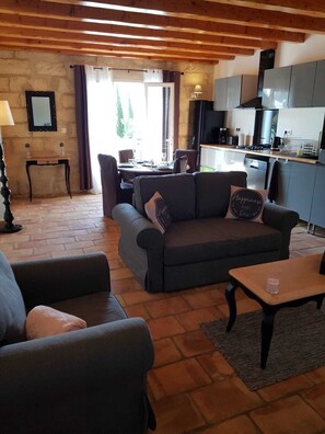 Ein gemütliches Wohnzimmer mit einer Couch, einem Couchtisch und einem Essbereich mit Tisch und Stühlen.