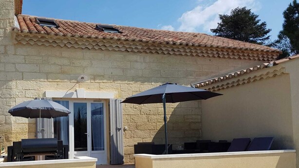 A patio with outdoor seating, a grill, and a covered entrance. - Mas St-Jean: Charm, Climate & Garden in Provence (saint pierre de mezoargue)