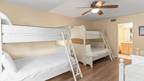 A room with bunk beds, a ceiling fan, and wooden flooring. - 1317 S Pacific - Unit C (Oceanside)