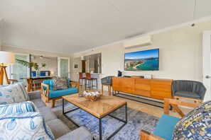 A modern living room with a sofa, armchairs, a coffee table, and a television. - @ Marbella Lane - Cozy 2BR w/ Amazing Ocean Views (Honolulu)