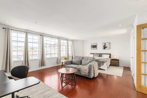 A modern living room with a sofa, a dining table, and a small side table. - @ Marbella Lane - Vibrant 5BR Home in Daly City (Daly City)