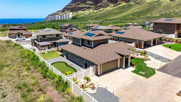 A residential area with houses featuring solar panels, a well-maintained lawn, and a view of the ocean. - @ML Ocean View, Golf, Gazebo and Bbq, we Have All! (Waianae)