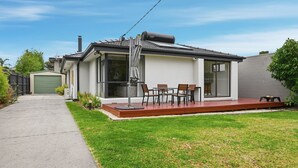 Une maison moderne dotée d’un patio, d’un garage et d’une pelouse bien entretenue.