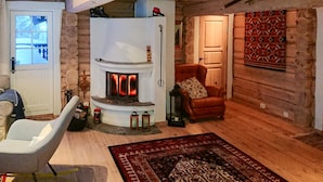 Une pièce chaleureuse avec une cheminée, un fauteuil en cuir, un tapis à motifs et un mur en bois.