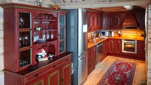 Une cuisine avec des meubles en bois, un réfrigérateur en acier inoxydable, un four à micro-ondes et un four traditionnel.