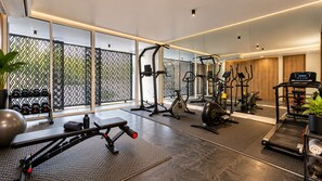 A modern gym with various exercise equipment, including a bench press, elliptical, and treadmill. - Sea Theatre Kata (Karon)