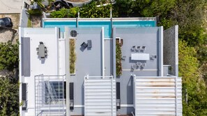 Vista aérea de una azotea con piscina, mobiliario exterior y una escalera.