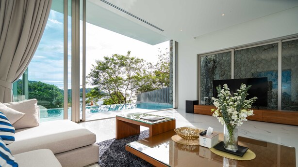 A modern living room with a glass coffee table, a sofa, and a large TV. - Sea Theatre Kata (Karon)