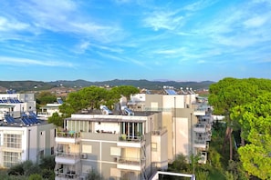 A residential building with multiple balconies, solar panels, and a view of distant hills. - Perla Holiday Homes 145, Lalzit Bay, Albania (Lalzit Bay)