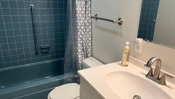 Chuveiro, toalhas de banho, sabonete, papel higiênico