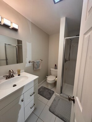 Chuveiro, toalhas de banho, sabonete, papel higiênico