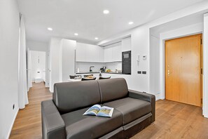 A modern living room with a brown leather sofa, a book on it, and a wooden floor. - Adria's House Modern, Riva del Garda, Italy (Riva del Garda)